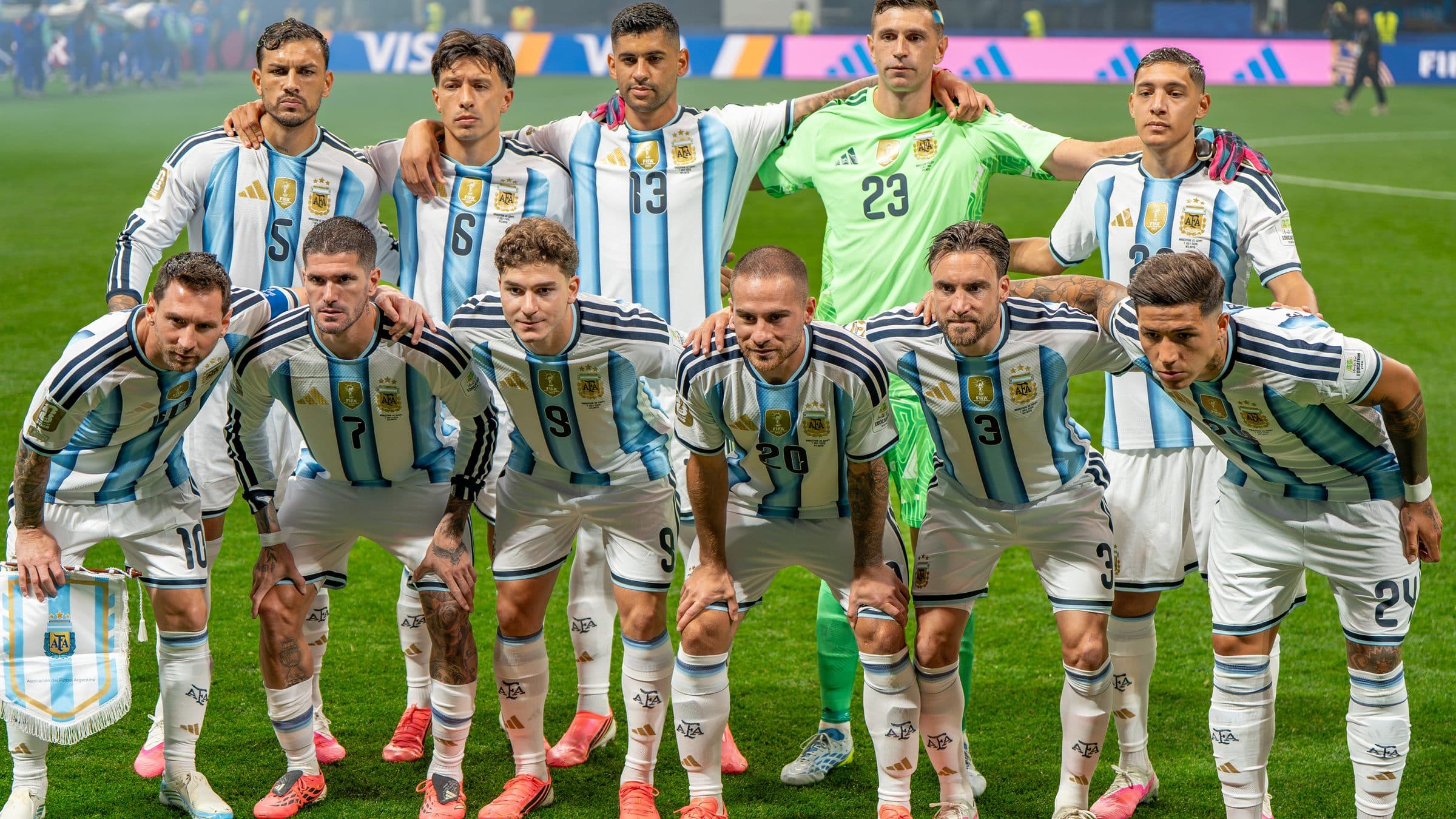 Time titular da Argentina perfilado antes de partida da Copa do Mundo de 2026, com Messi agachado à esquerda segurando a flâmula de capitão